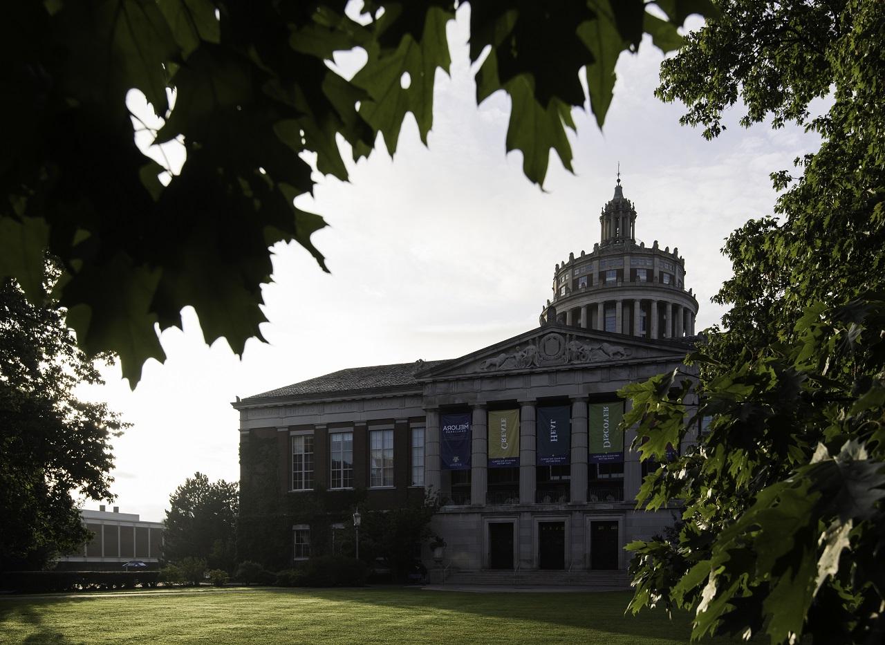 University of Rochester's Rush Rhees Library is pictured through the leaves of a tree